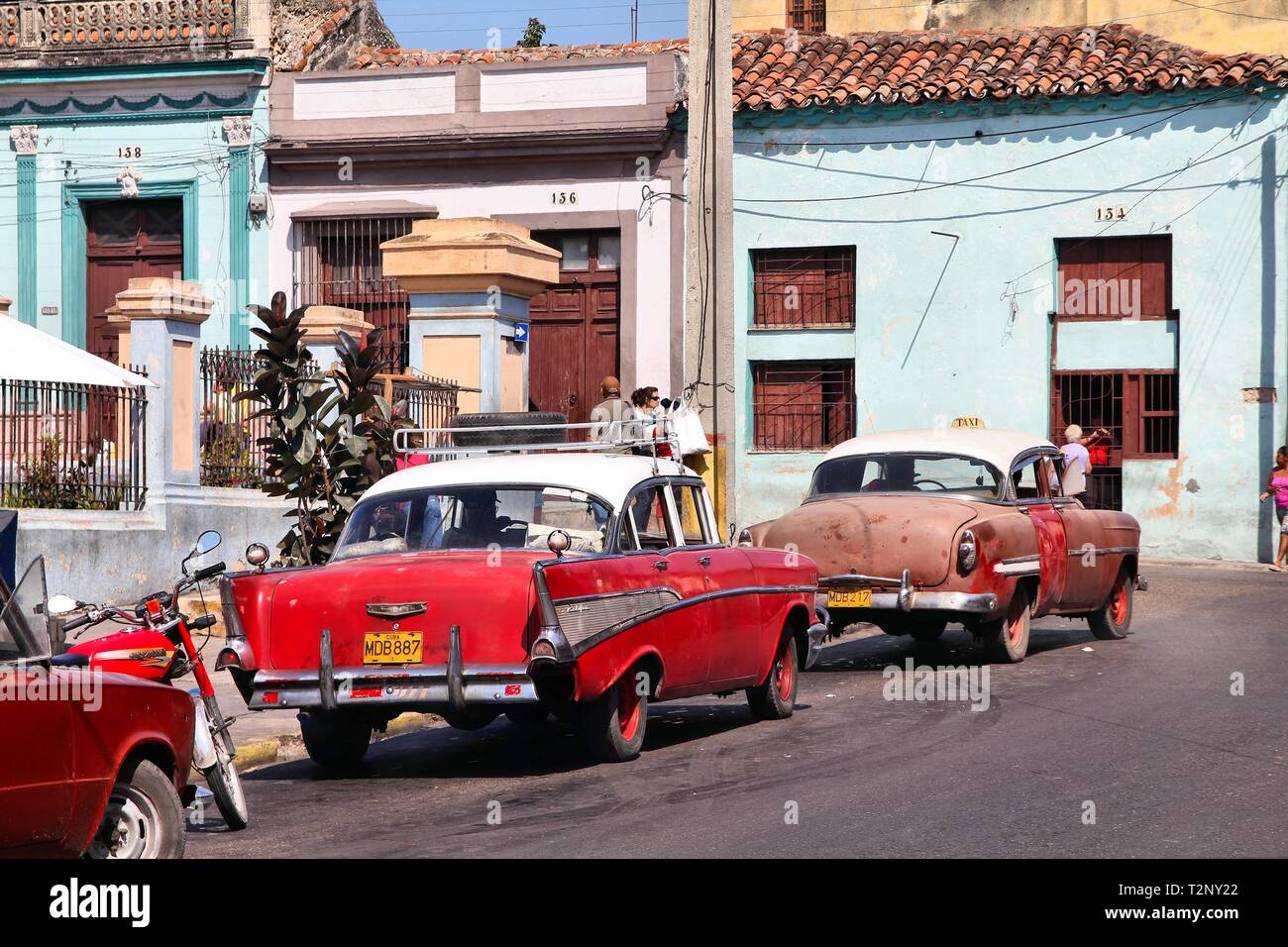 MATANZAS, CUBA - febbraio 22: la gente a piedi passato le vecchie autovetture il 22 febbraio 2011 in Matanzas, Cuba. Nuova modifica della legge consente di cubani al commercio di automobili. In auto Foto Stock