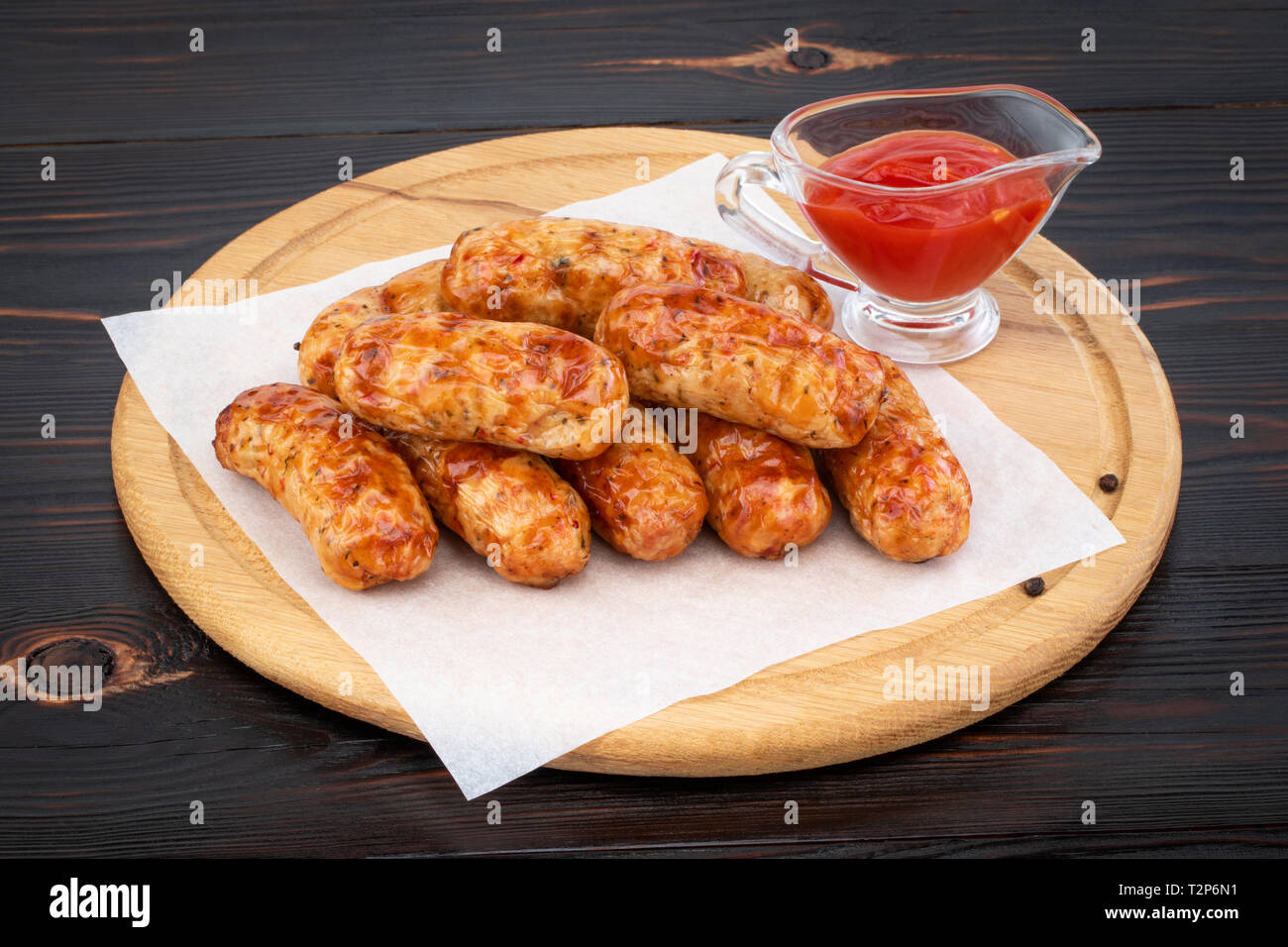 Gustose salsicce alla griglia sullo sfondo di legno. Foto Stock