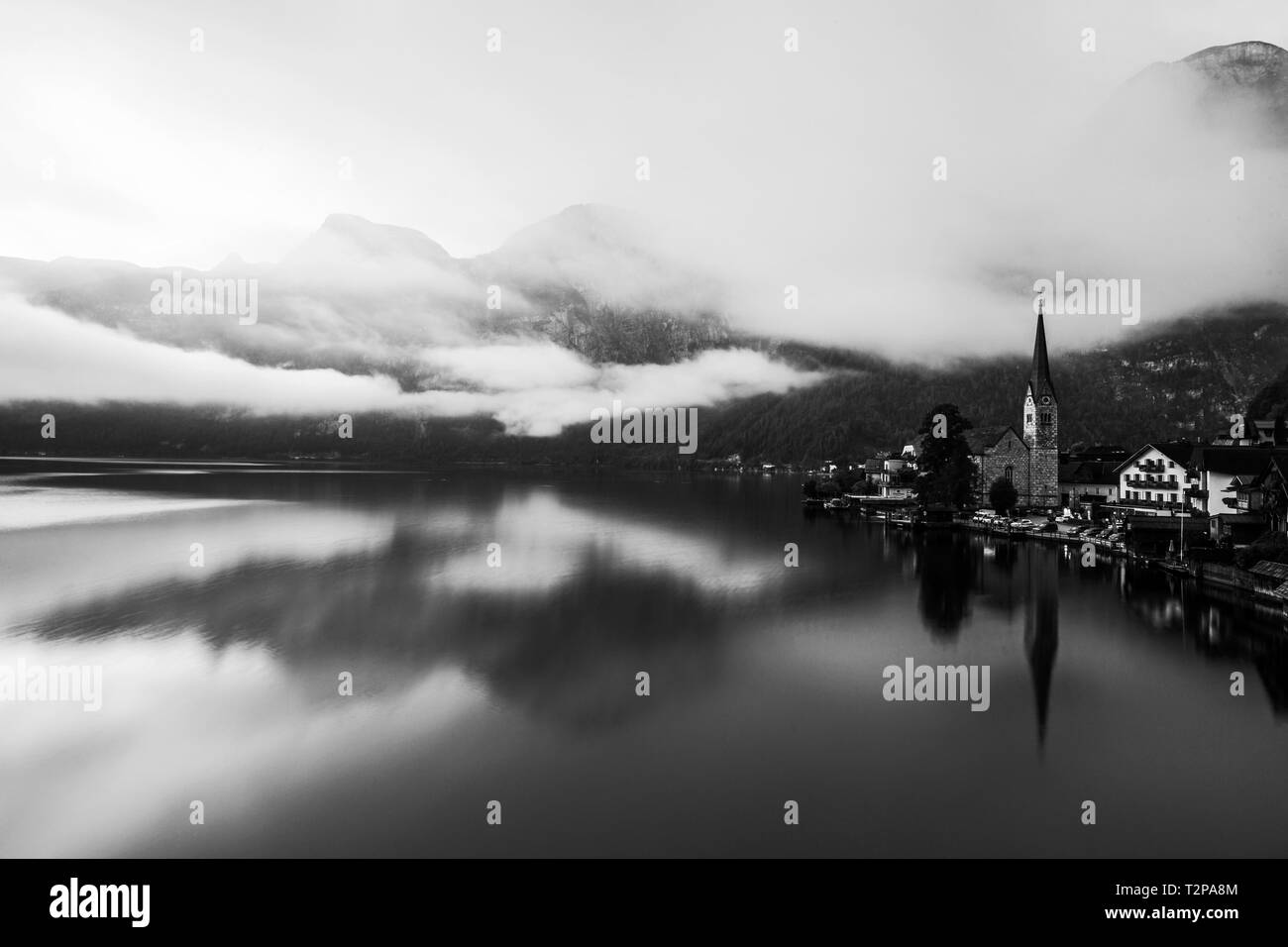 La fantastica vista di Hallstatt immerso tra il lago con una inversione di cloud di arrotolamento attraverso il picco. Foto Stock