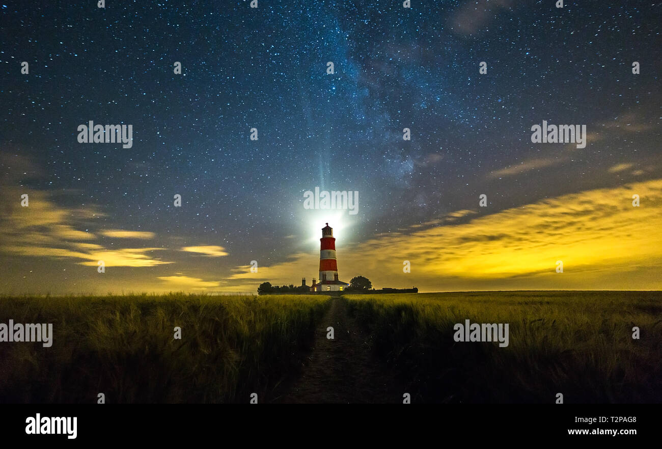 Happisburgh, Norfolk, Regno Unito, 28 Luglio 2016 - Mostra Happisburgh lighthouse di notte con la via lattea sulla Costa North Norfolk, utilizzata per illuminare il cl Foto Stock