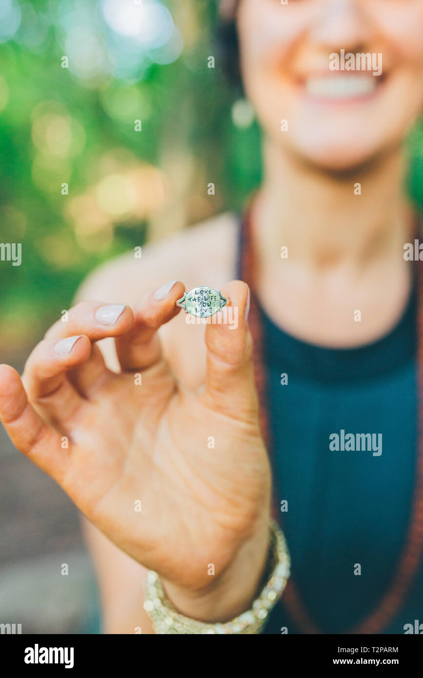 Donna anello di tenuta con le parole 'l'amore e la vita che vivo' Foto Stock