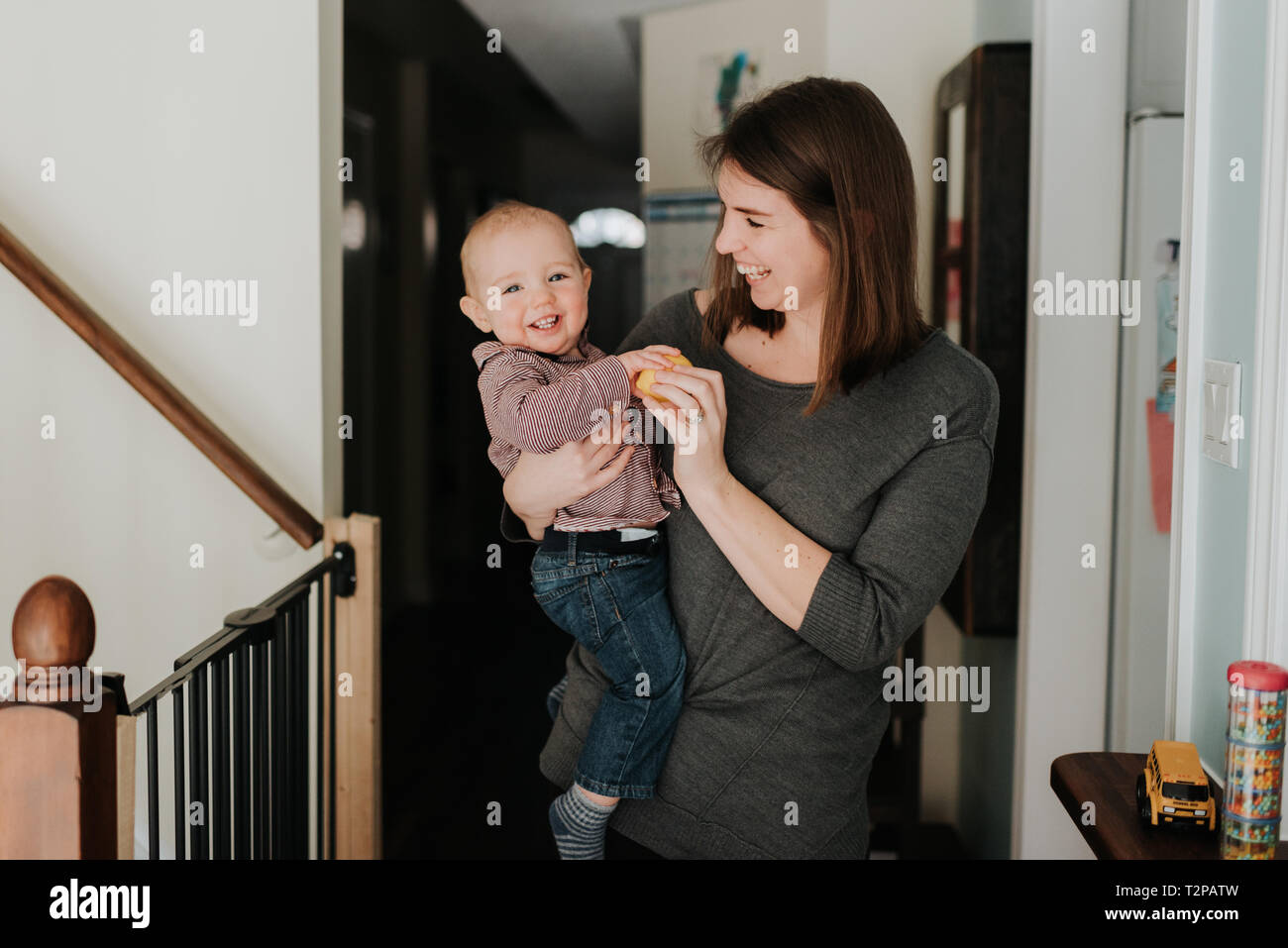 Madre bambino portando figlio di armi, ritratto Foto Stock
