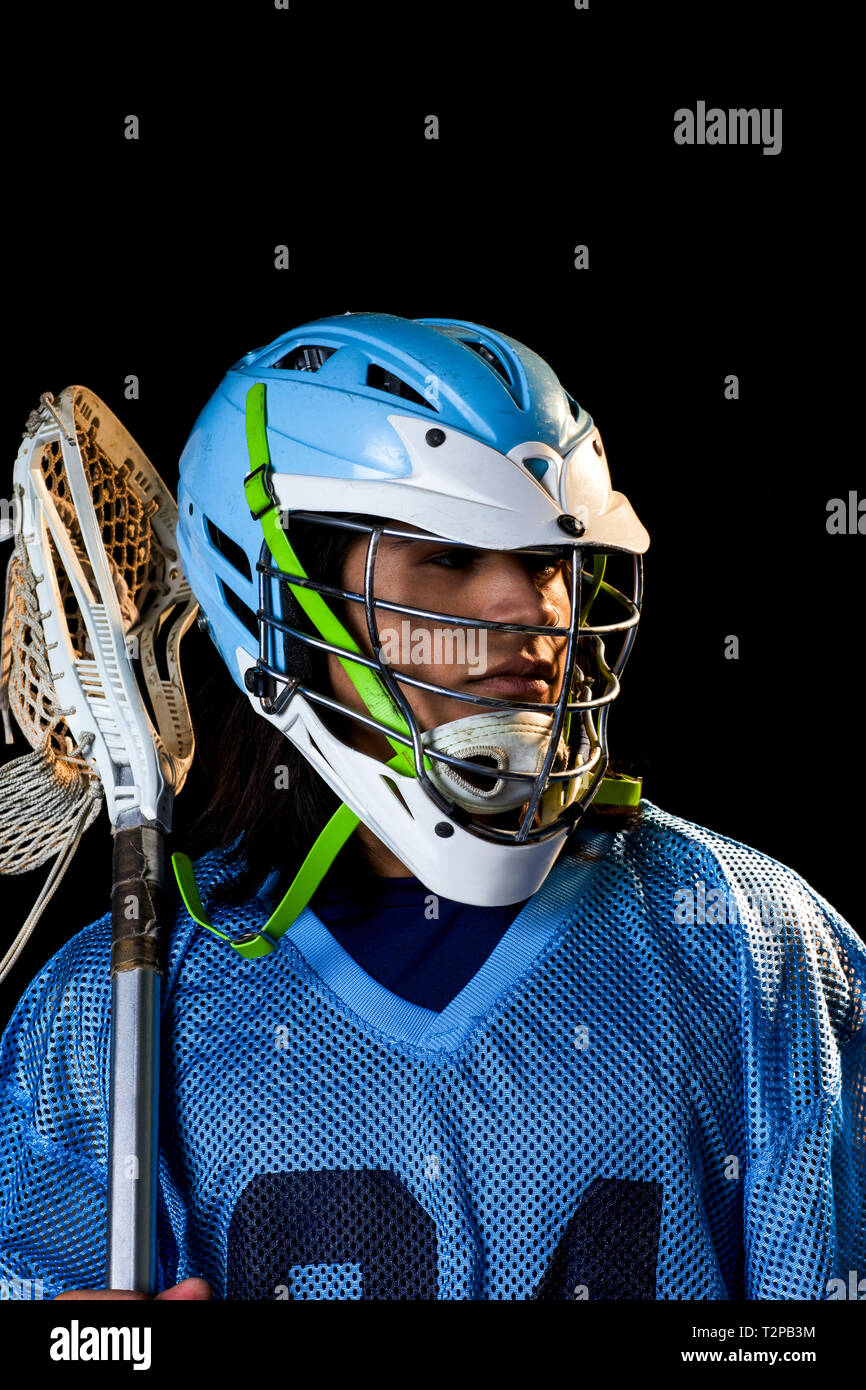Giovane maschio lacrosse player con lacrosse stick, ritratto su sfondo nero Foto Stock