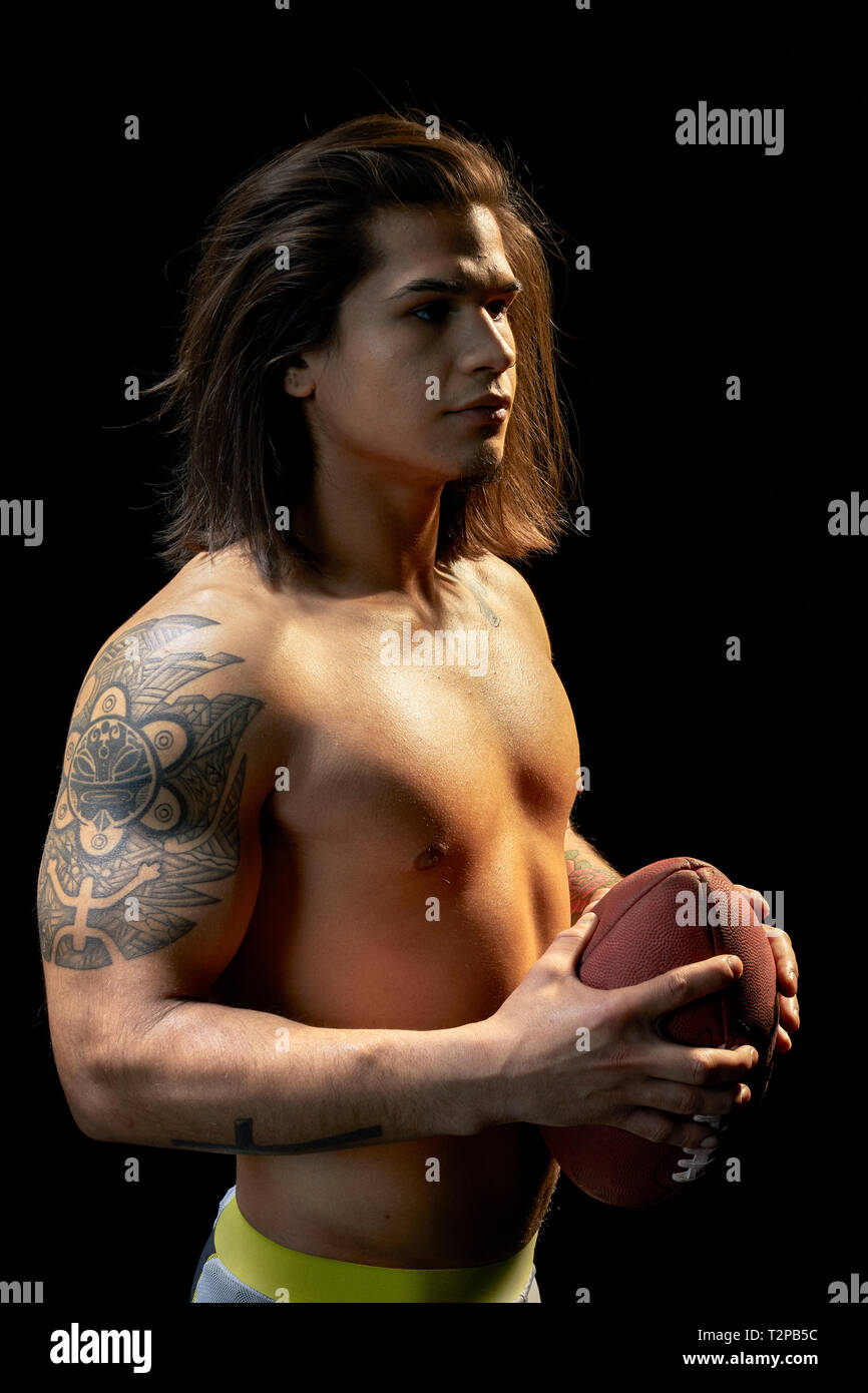 Ritratto di bare chested giovane con il calcio, sfondo nero Foto Stock