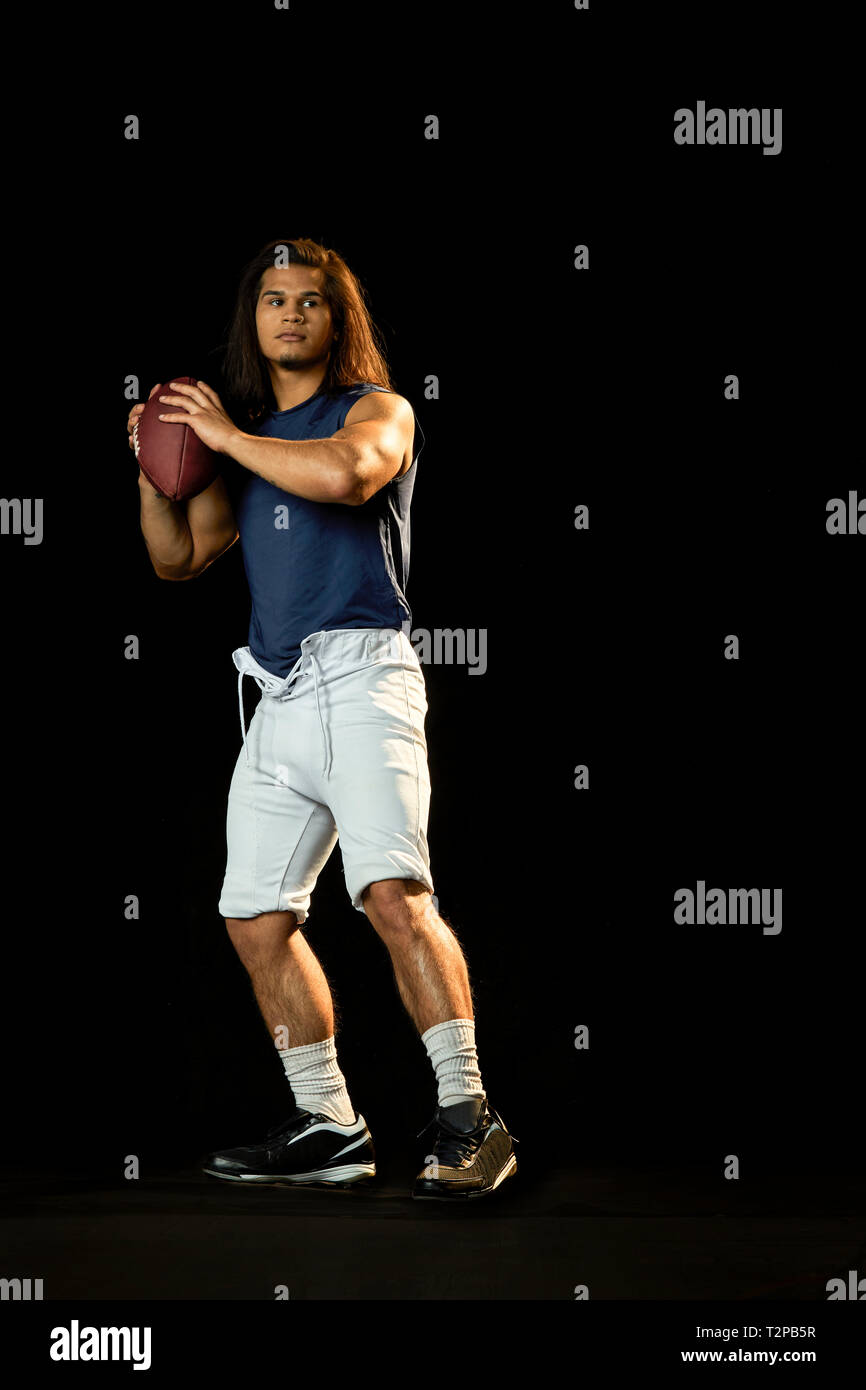 Ritratto di giocatore di calcio con calcio, sfondo nero Foto Stock
