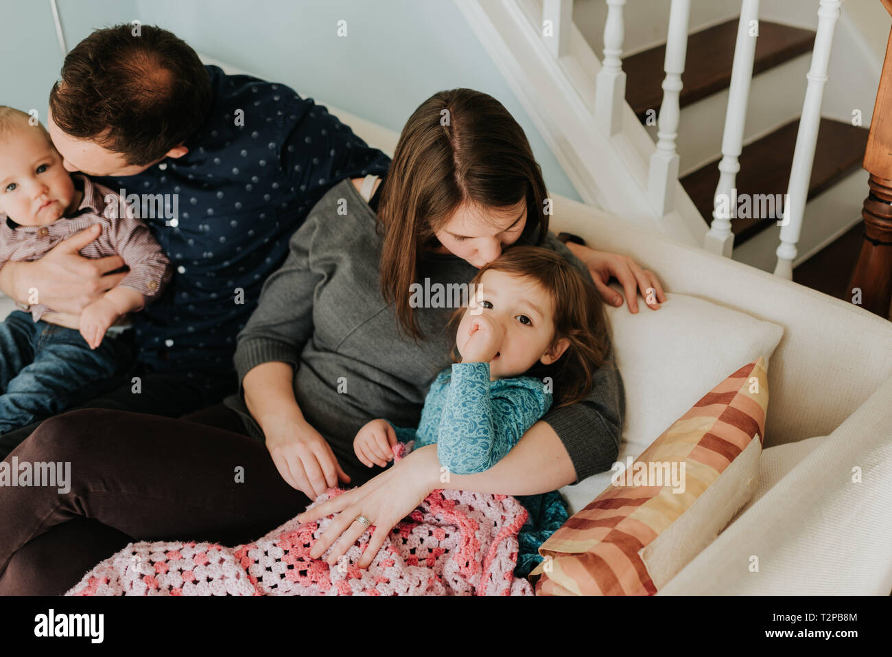 Metà adulto giovane sul divano con il bambino figlio e figlia dei bimbi Foto Stock
