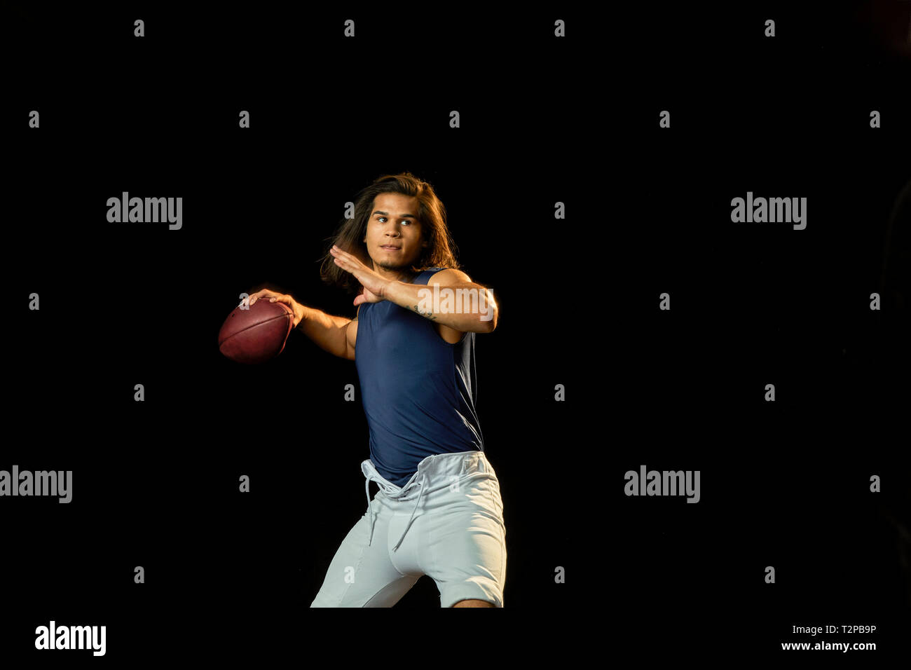 Ritratto di giocatore di calcio con calcio, sfondo nero Foto Stock