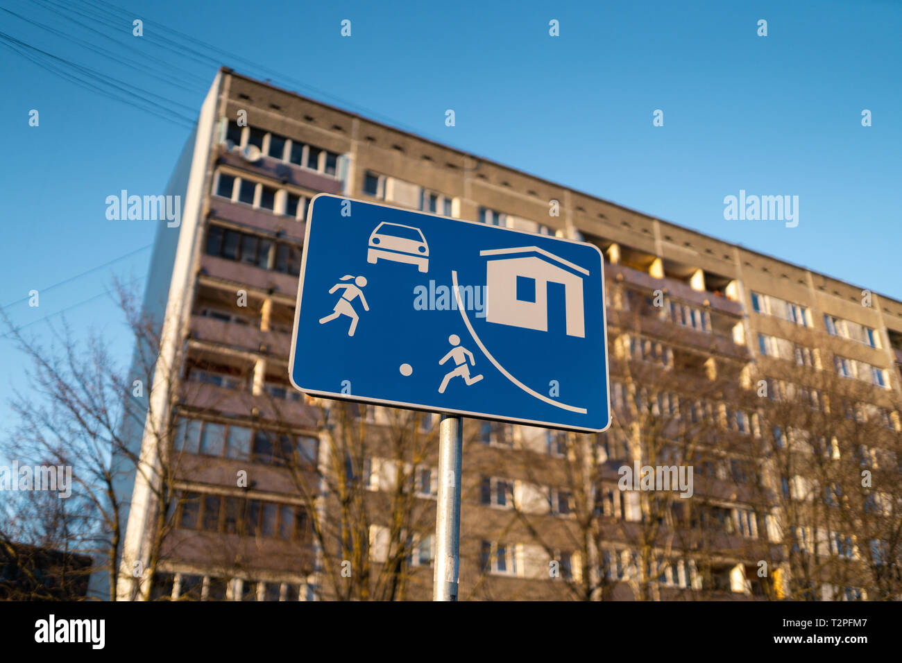 Settore viva strada europea firmano a Riga, Lettonia con un tipico blocco sovietico di appartamenti house edificio in background - tempo soleggiato Foto Stock