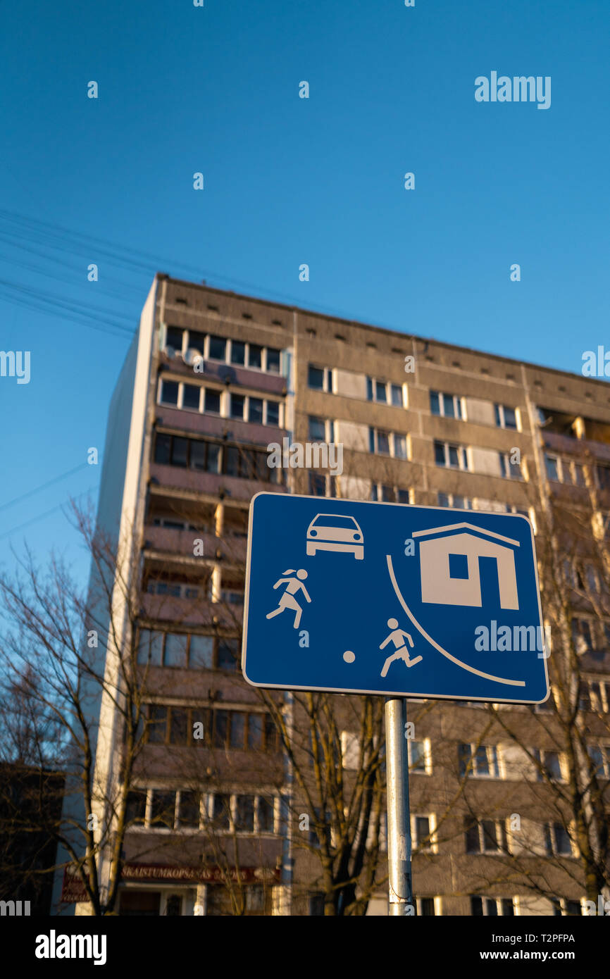 Settore viva strada europea firmano a Riga, Lettonia con un tipico blocco sovietico di appartamenti house edificio in background - tempo soleggiato Foto Stock