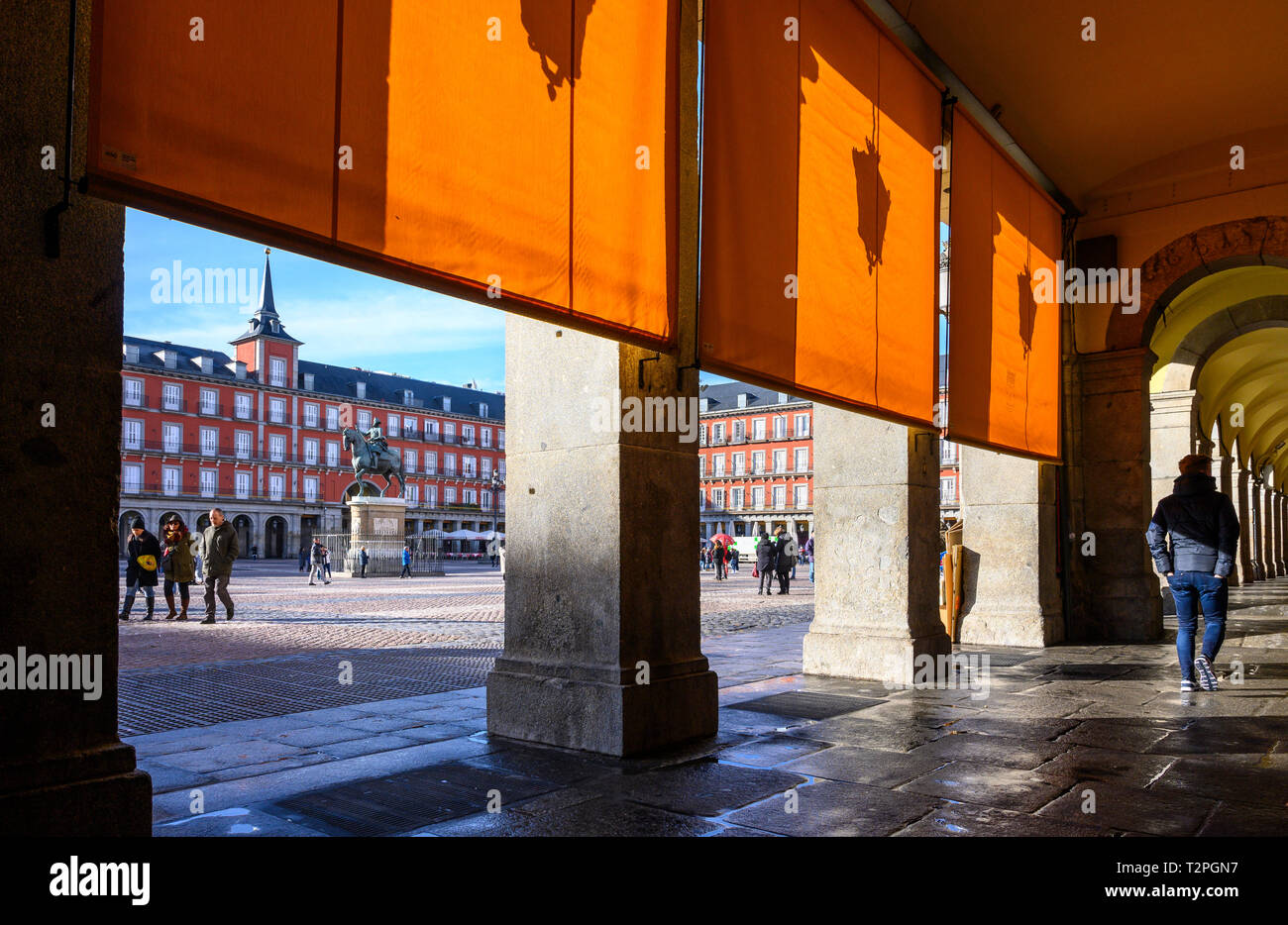 All'ombra degli archi in Plaza Mayor nel centro di Madrid, Spagna Foto Stock