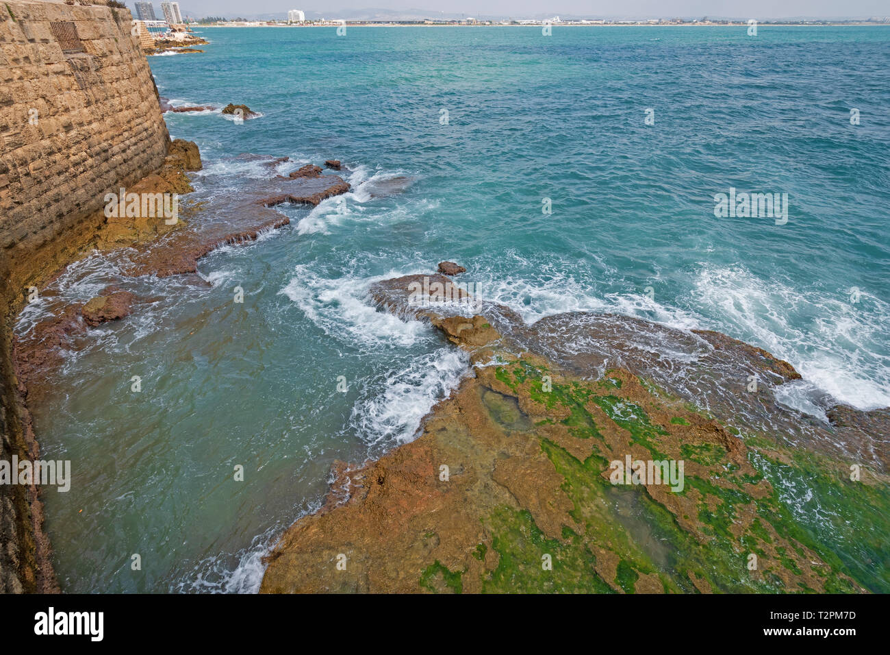 Onde che si infrangono lungo pareti costiere di una fortezza in acri, Israele Foto Stock
