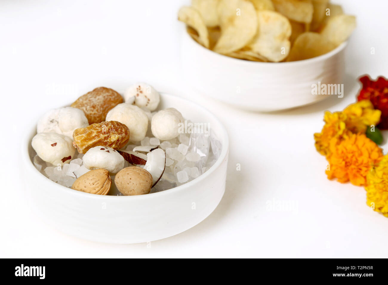 Foto di mescolare la frutta secca e i chip nella ciotola. Isolato su uno sfondo bianco. Foto Stock