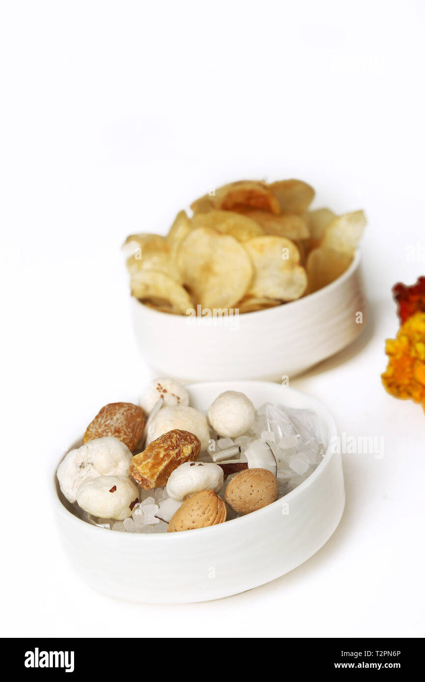 Ritratto di mescolare la frutta secca e i chip nella ciotola. Isolato su uno sfondo bianco. Foto Stock