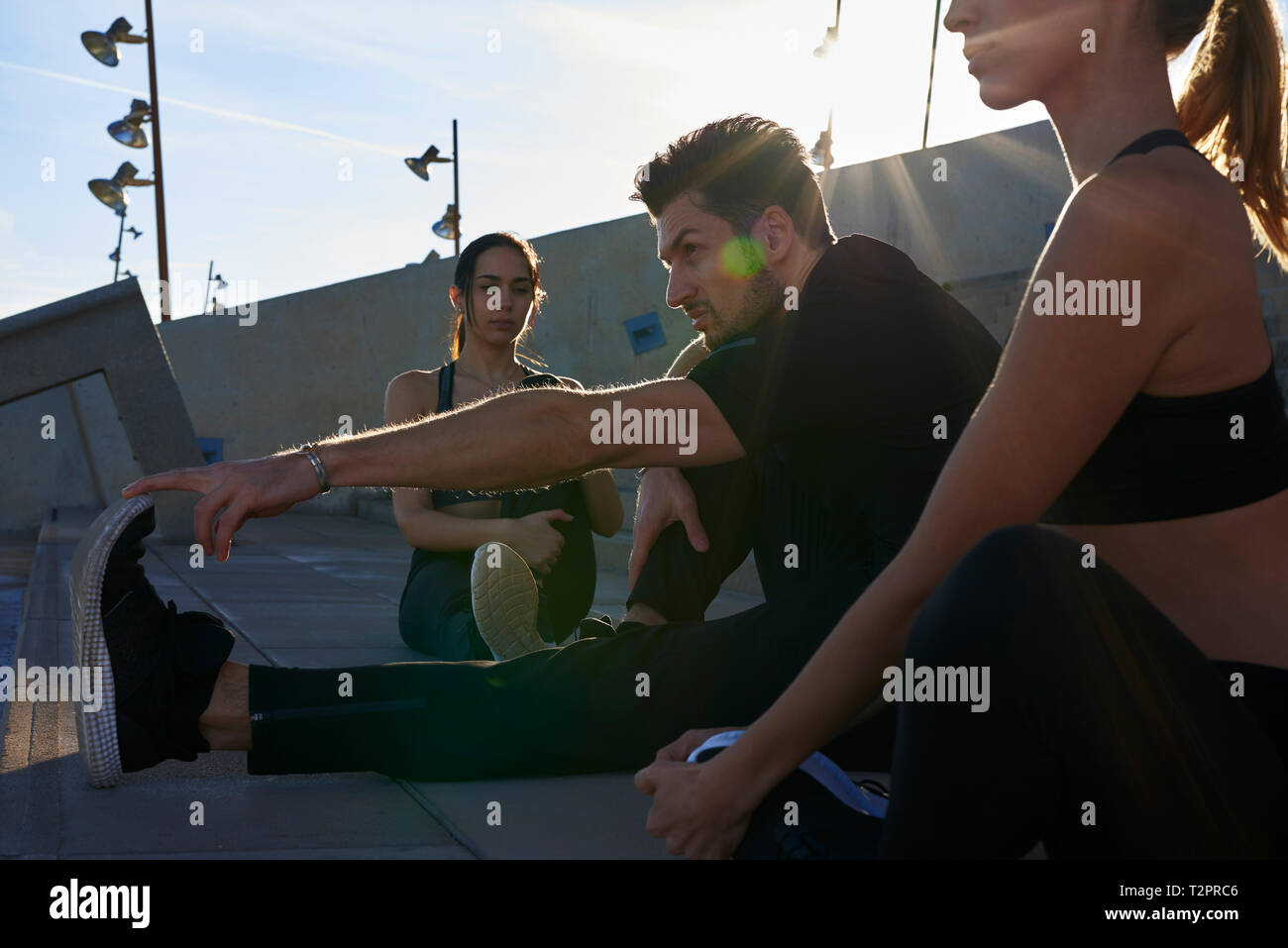 Gli amici lo stretching sui passi in stadio sportivo Foto Stock