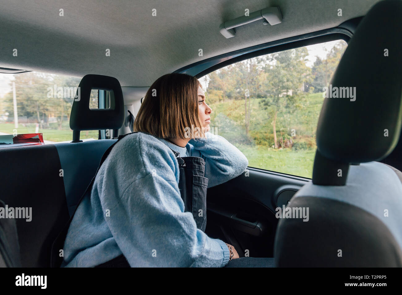 Donna che guarda fuori della finestra in backseat di auto Foto Stock