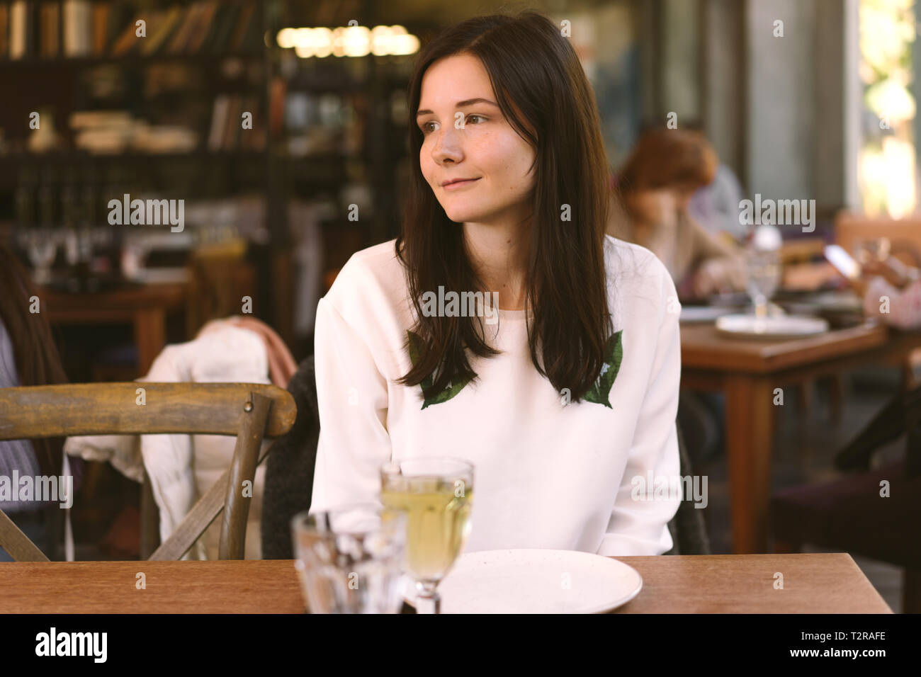 Pretty Woman gustando un pasto in un ristorante accogliente Foto Stock