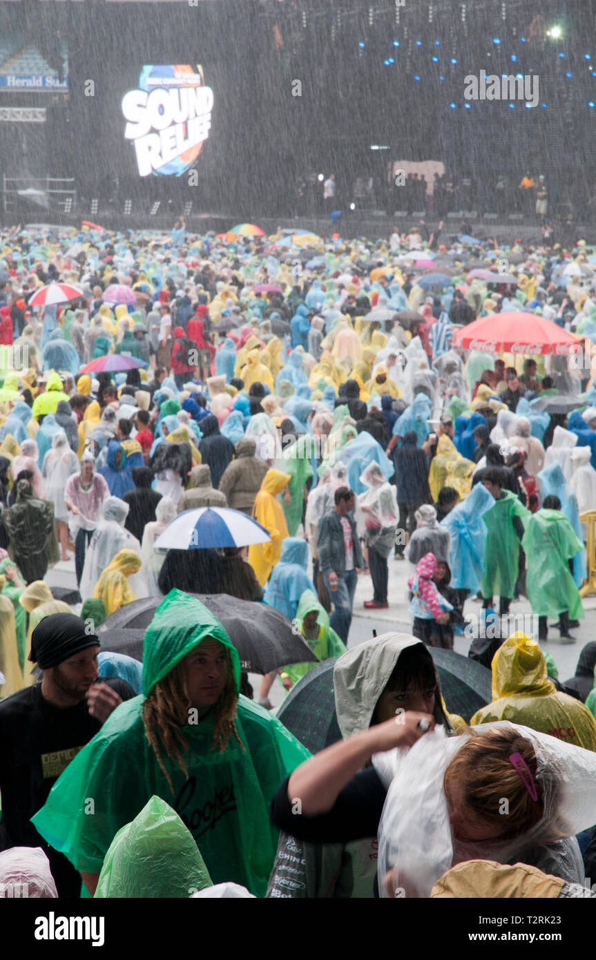 Folla in piedi nella pioggia battente al concerto rock Foto Stock