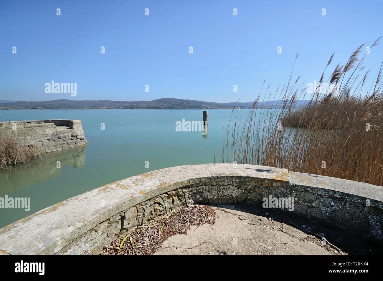 Vista panoramica di italiano Lago Trasimeno con pier nel litorale, in una giornata di sole Foto Stock