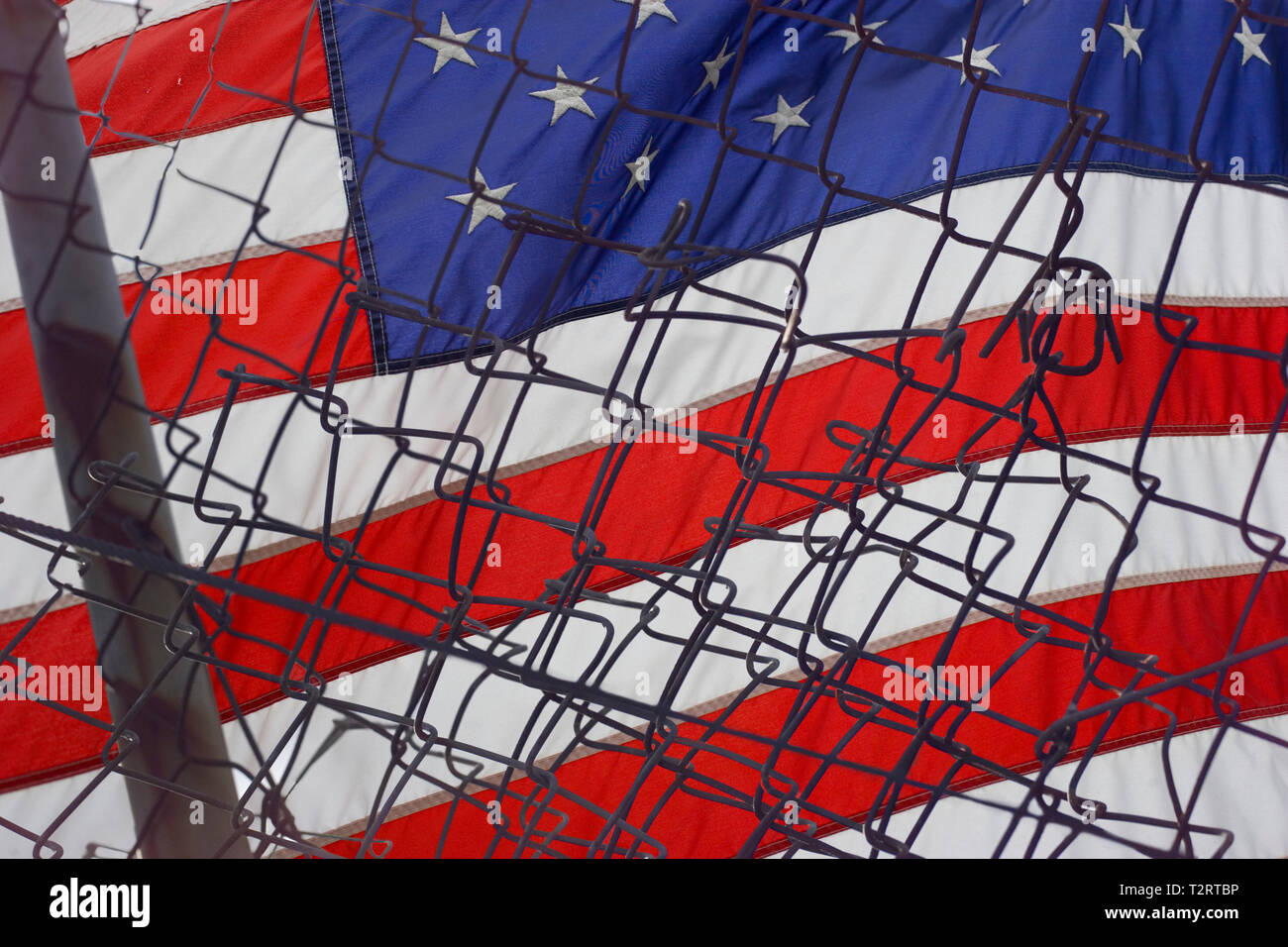 Bandiera americana dietro un arrugginito, recinzione rotto Foto Stock