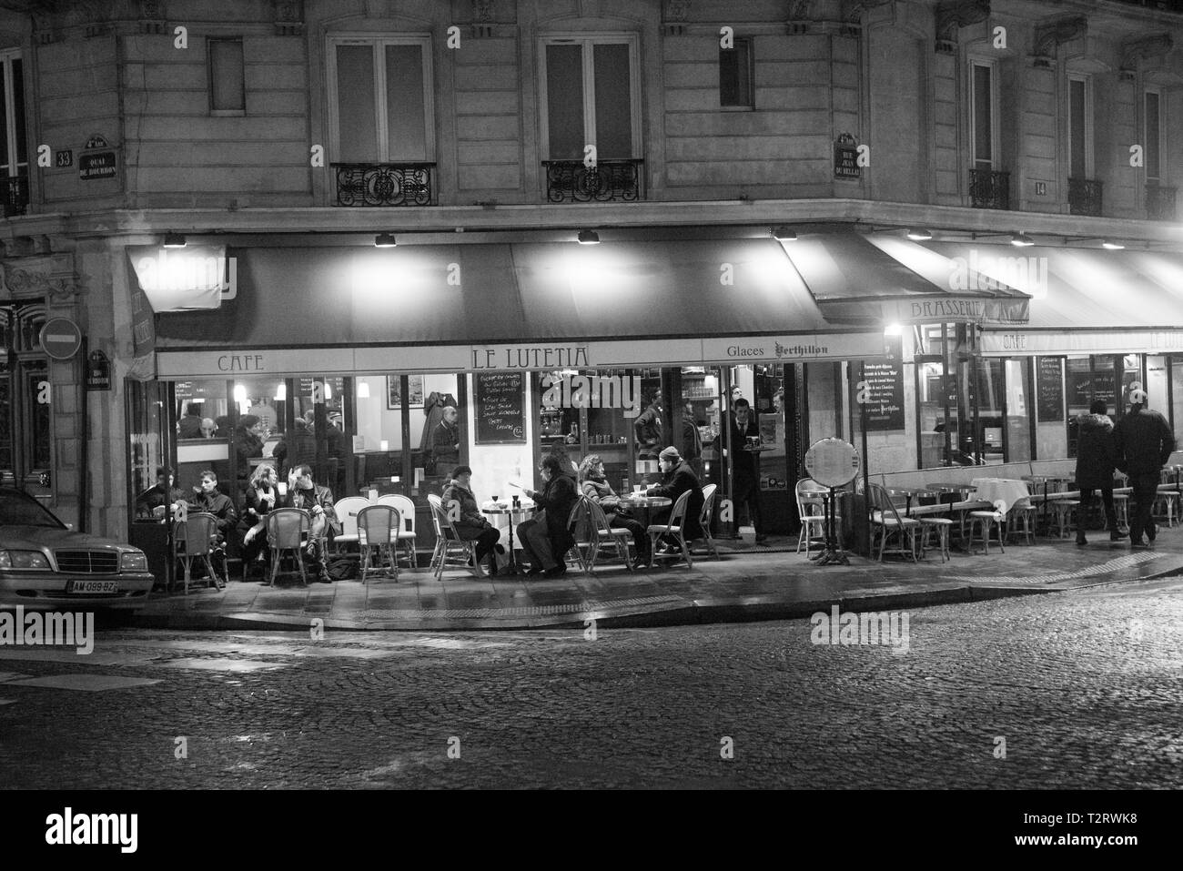 Scena sul marciapiede del Bistrot di Parigi di notte in bianco e nero Foto Stock