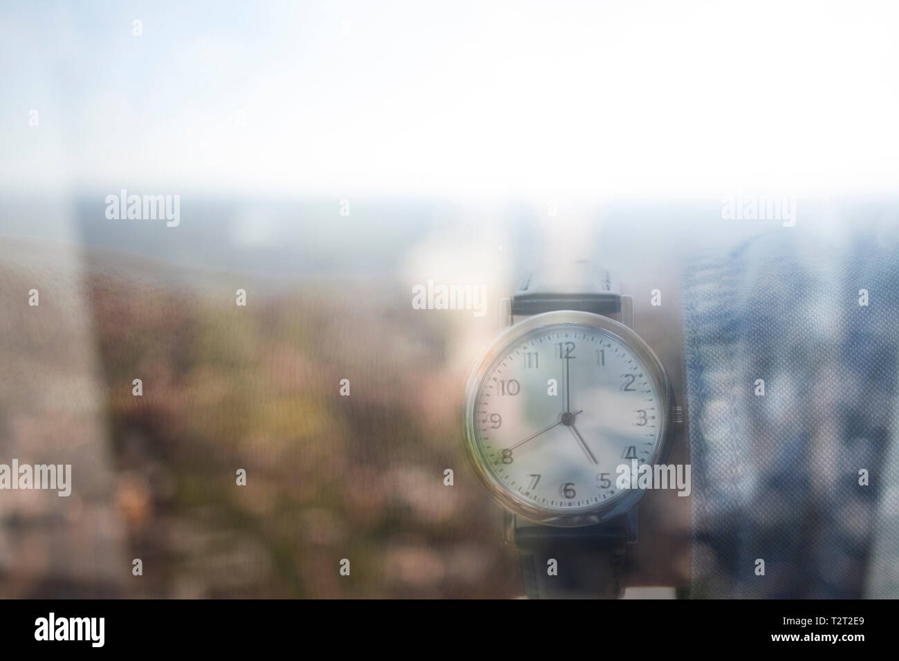 La riflessione di un uomo caucasico indossando un orologio da polso che mostra il tempo 5:00 Foto Stock