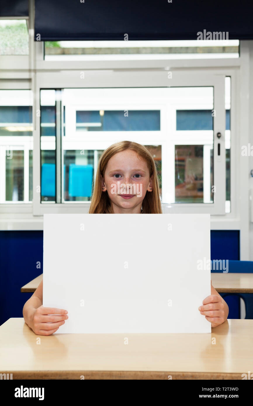 La scuola primaria caucasian ragazza con targhetta vuota Foto Stock