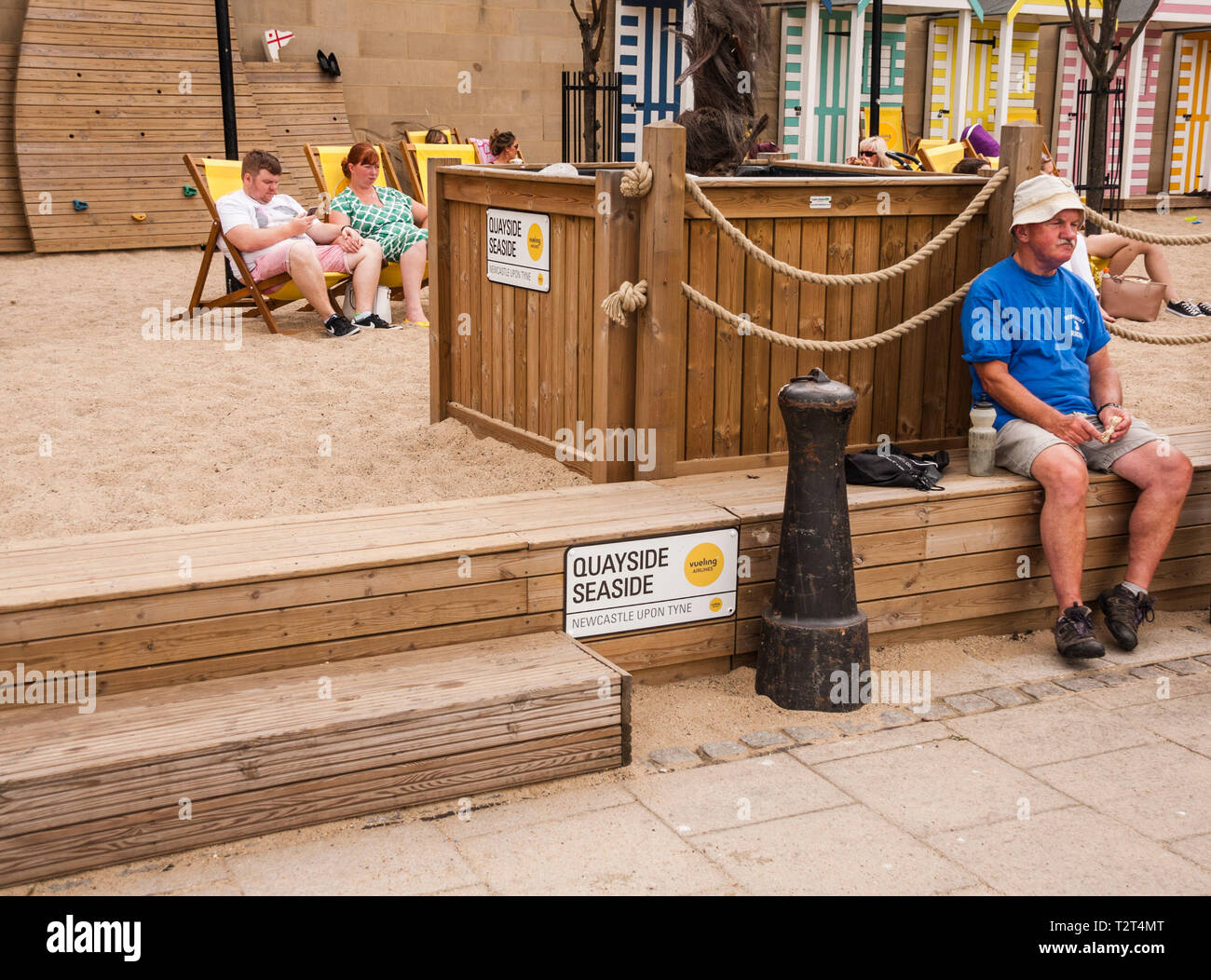 Persone relax sulle sedie a sdraio presso la banchina di locali sul mare vicino alle rive del Fiume Tyne a Newcastle upon Tyne Foto Stock