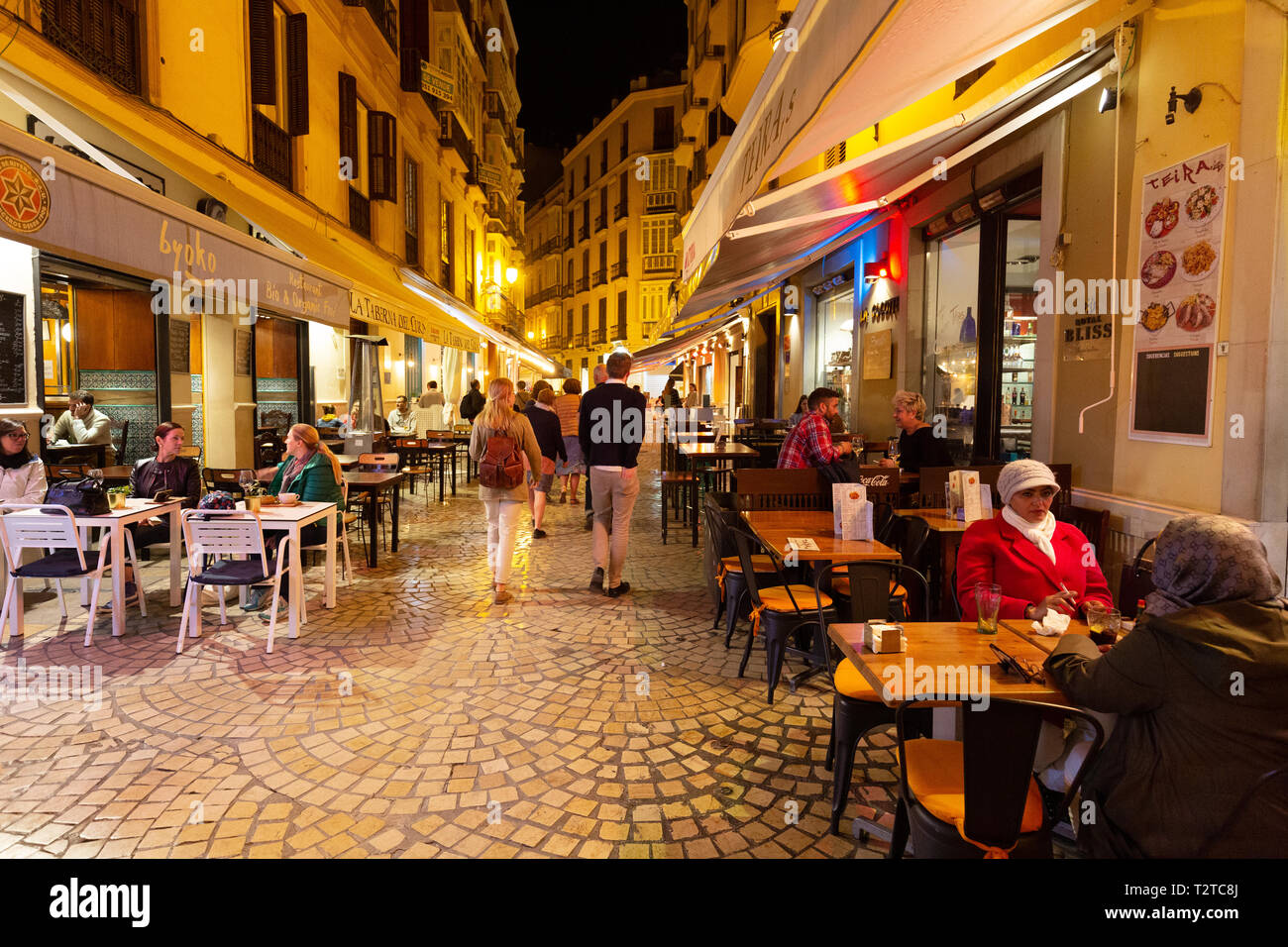 Ristoranti di Malaga - Strada con gente seduta di mangiare in ristoranti caffè e tapas bar di notte, Malaga città vecchia, Andalusia Spagna Foto Stock