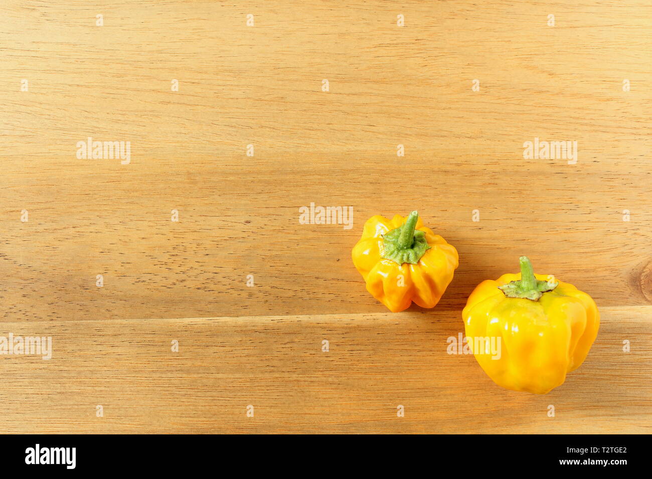 Composizione del giallo fresco Scotch Bonnet il peperoncino su una tavola di legno con spazio di copia Foto Stock