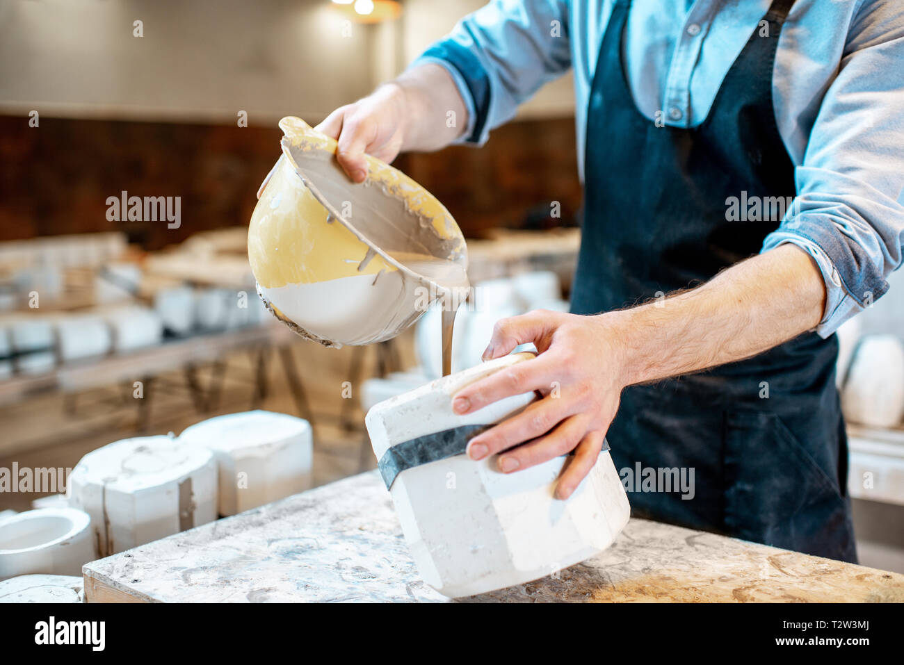 Lavoratore di versamento liquido speciale nella forma di gesso rendendo i prodotti ceramici alla fabbricazione ceramica, vista da vicino Foto Stock