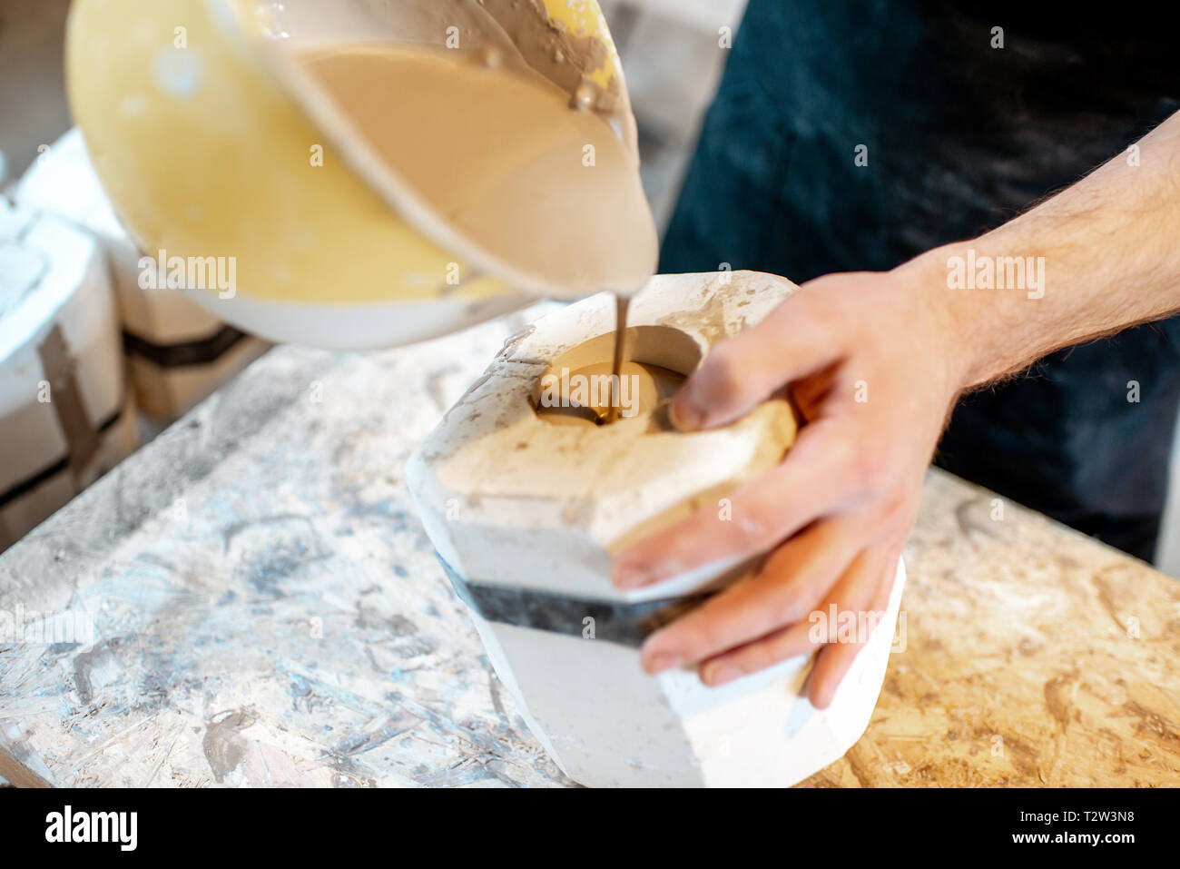 Lavoratore di versamento liquido speciale nella forma di gesso rendendo i prodotti ceramici alla fabbricazione ceramica, vista da vicino Foto Stock