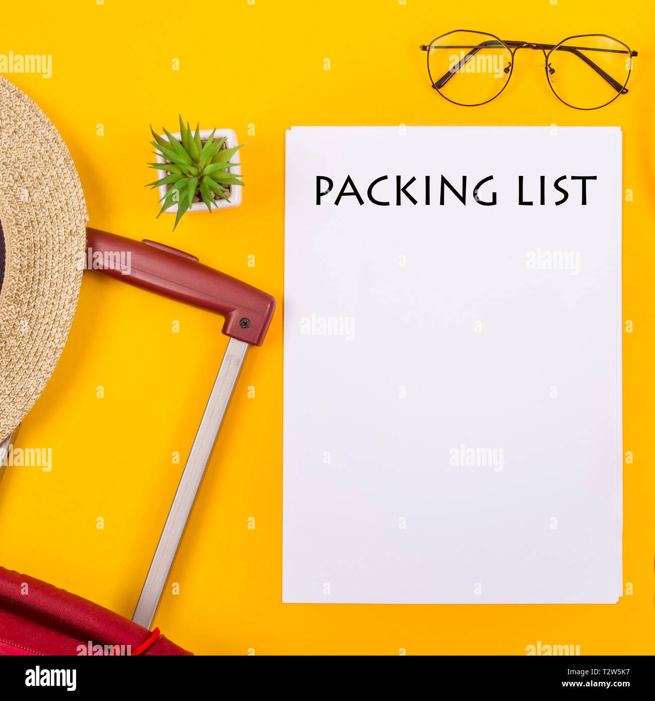 La lista di imballaggio per il viaggio è prossima ad una valigia, una tazza di caffè e una cannuccia estate borsa su uno sfondo giallo. Tenetevi pronti per un concetto di viaggio Foto Stock