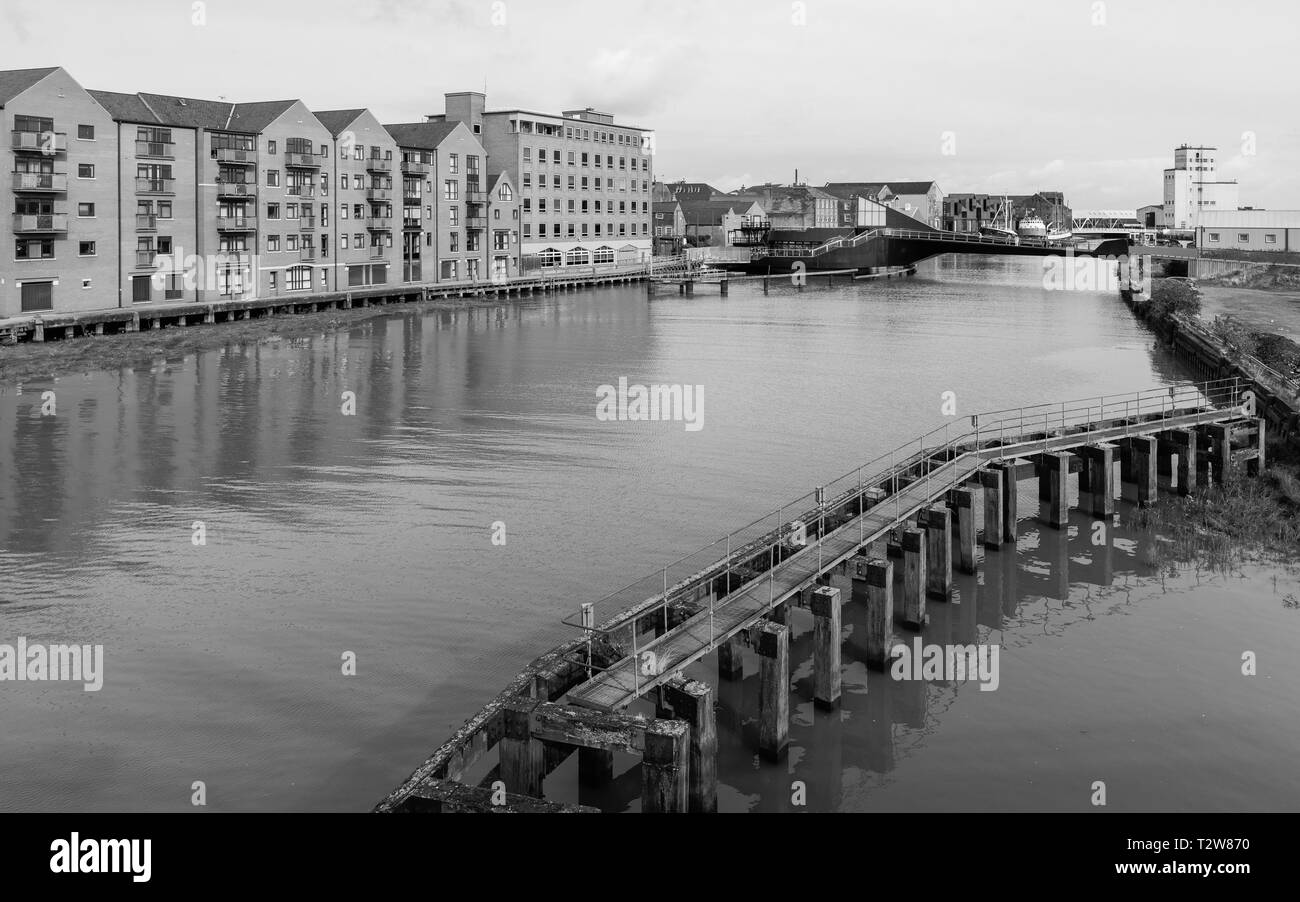 Fiume Hull affiancato da moderni appartamenti e uffici e abbandonati e Causeway Lane scala ponte in Hull, Yorkshire, Regno Unito. Foto Stock