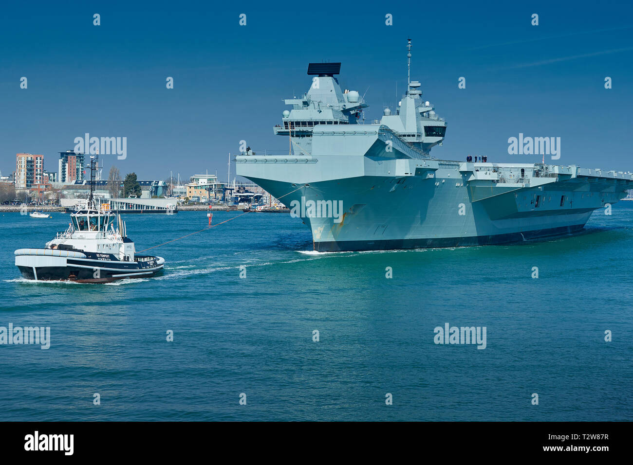 La Royal Navy portaerei HMS QUEEN ELIZABETH, coadiuvato dal rimorchiatore tempesta SD, come ella si diparte Portsmouth per Rosyth, Scozia. 01 aprile 2019. Foto Stock