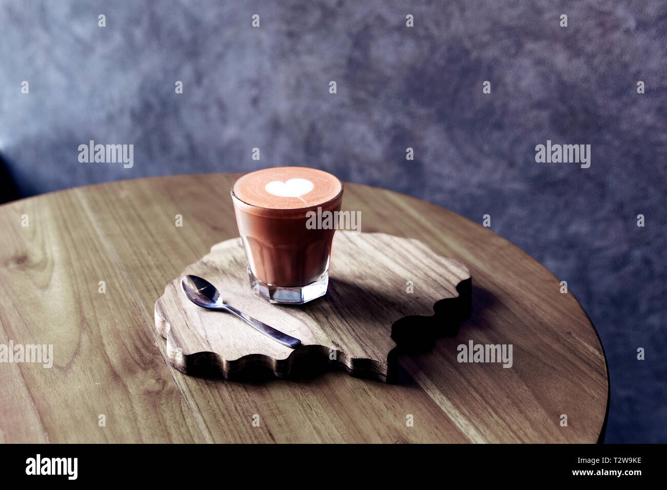 Bicchiere di questi gustosi con amore arte sul tavolo di legno e la tessitura della scrivania. Concetto di mattina. Foto Stock