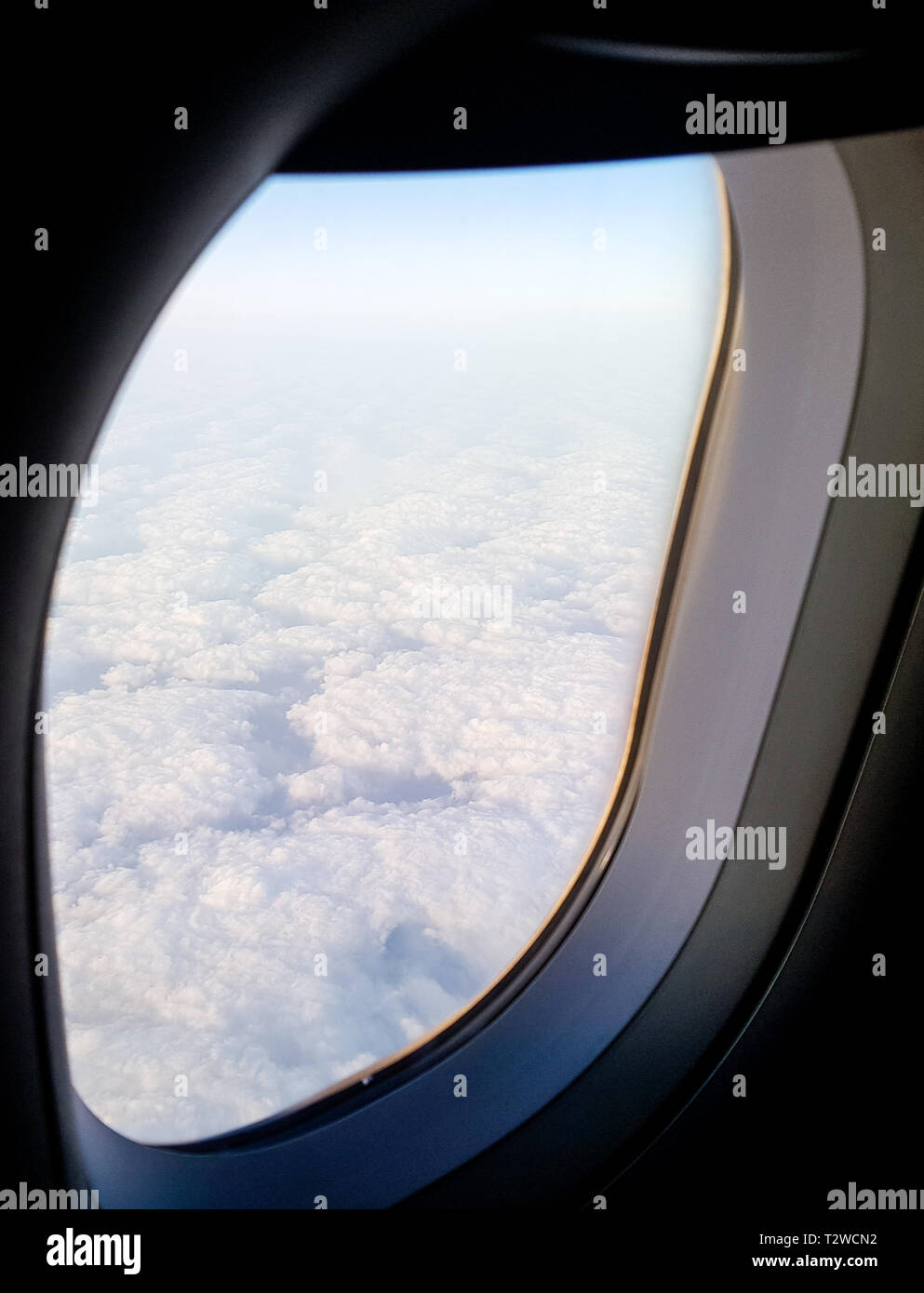 Nuvole visto da sopra attraverso un aereo finestrino di cabina Foto Stock