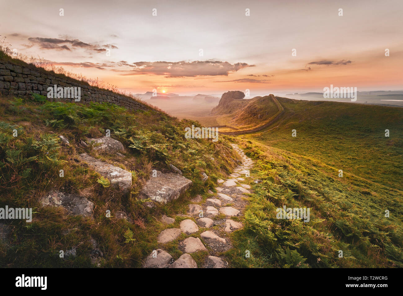 Parco nazionale di Northumberland. Alba sul percorso vicino a Cuddy di Craig sul vallo di Adriano guardando ad est verso Housesteads Craig e il Rising Sun. Foto Stock