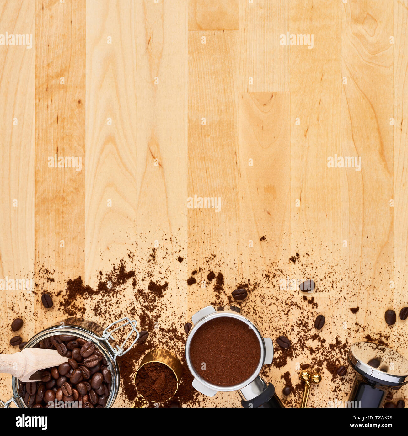 Un assortimento di caffè in grani, il caffè macinato, portafilter e manomissione su sfondo di legno. Vista superiore del caffè sfondo. Lay piatto. Copia spazio per il testo. Baris Foto Stock