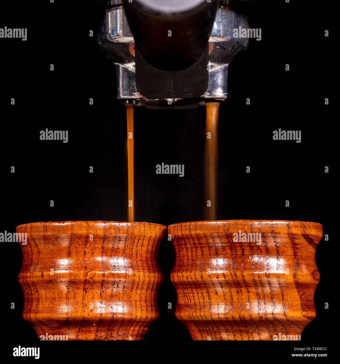 I caffè sono in fase di preparazione in piccole coppe in legno da una macchina per il caffè. Foto Stock