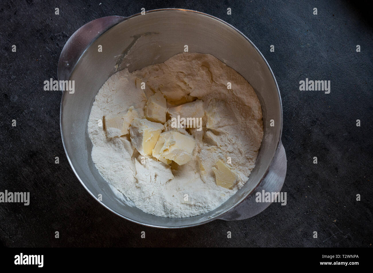 Una ciotola con il lievito in polvere e il burro, pronto per essere mescolato. Preparazione per la cottura in forno di casa. Vista superiore Foto Stock