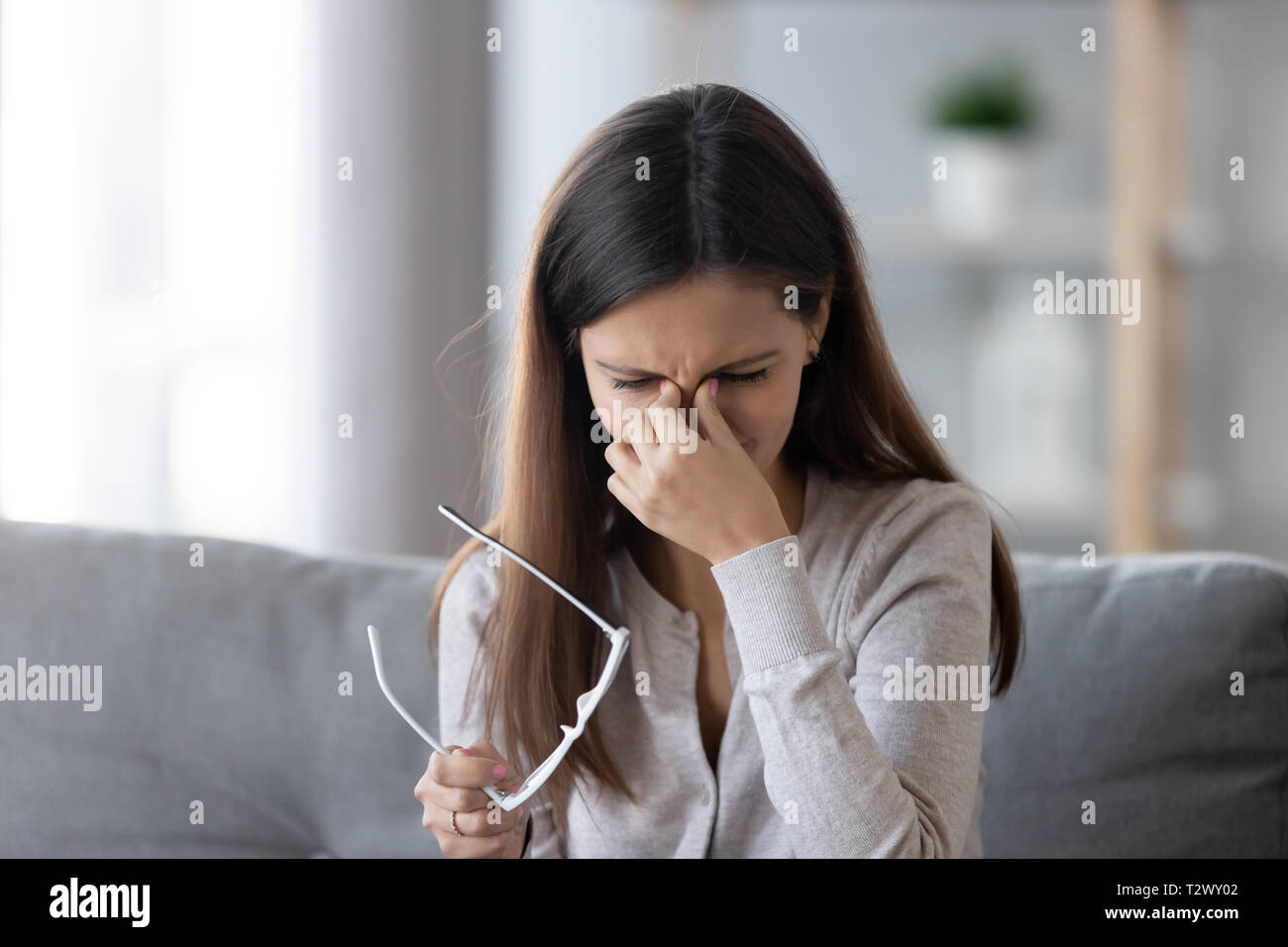 Femmina di togliere i bicchieri massaggiando ponte nasale sensazione di affaticamento della vista Foto Stock