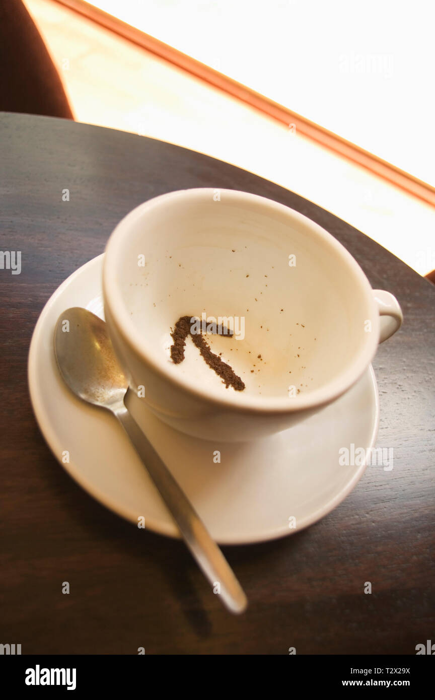 Le foglie di tè in una tazza da tè a forma di freccia Foto Stock