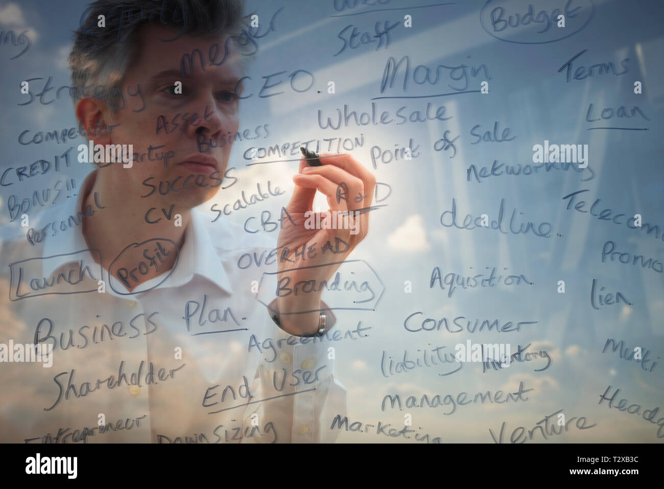La riflessione di un imprenditore creativo brainstorming scrivendo parole chiave business su vetro Foto Stock