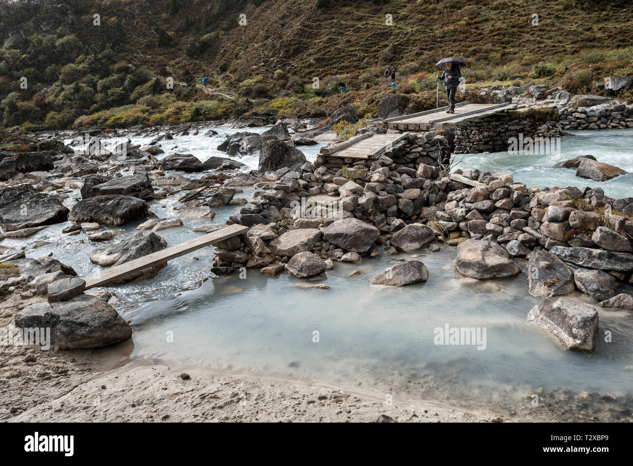 Attraversare un fiume vicino Thrika camp, Gasa distretto, Snowman Trek, Bhutan Foto Stock
