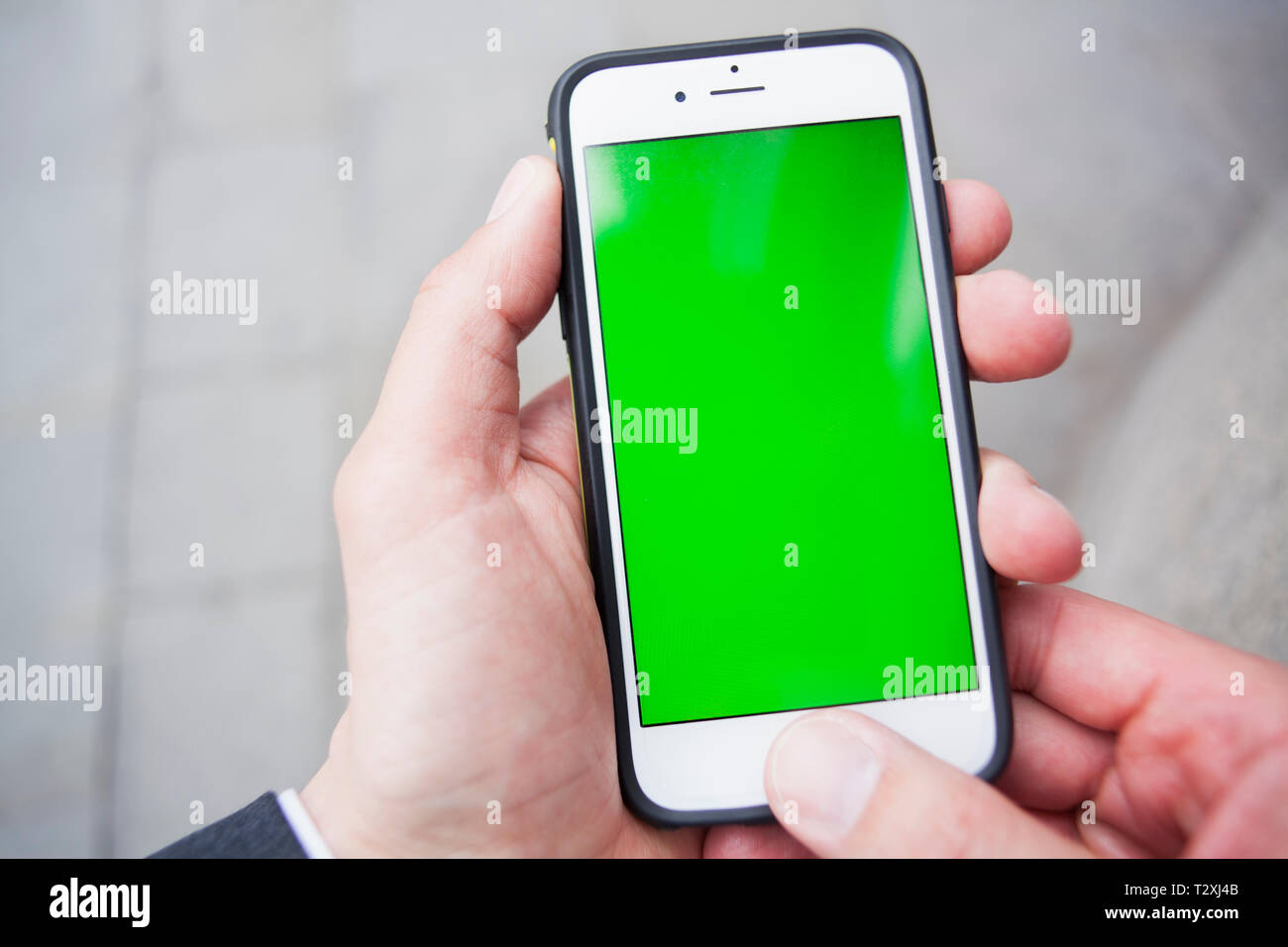 Punto di vista personale di un uomo utilizzando uno smartphone con schermo verde Foto Stock