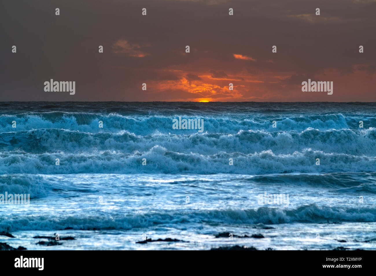 Tramonto su un mare agitato Foto Stock