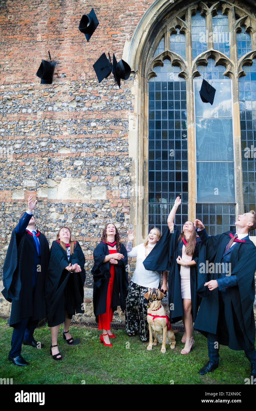 Cattedrale di Chelmsford, studenti buttare la loro scheda di mortaio cappelli in aria nella celebrazione di passare i loro gradi. Foto Stock