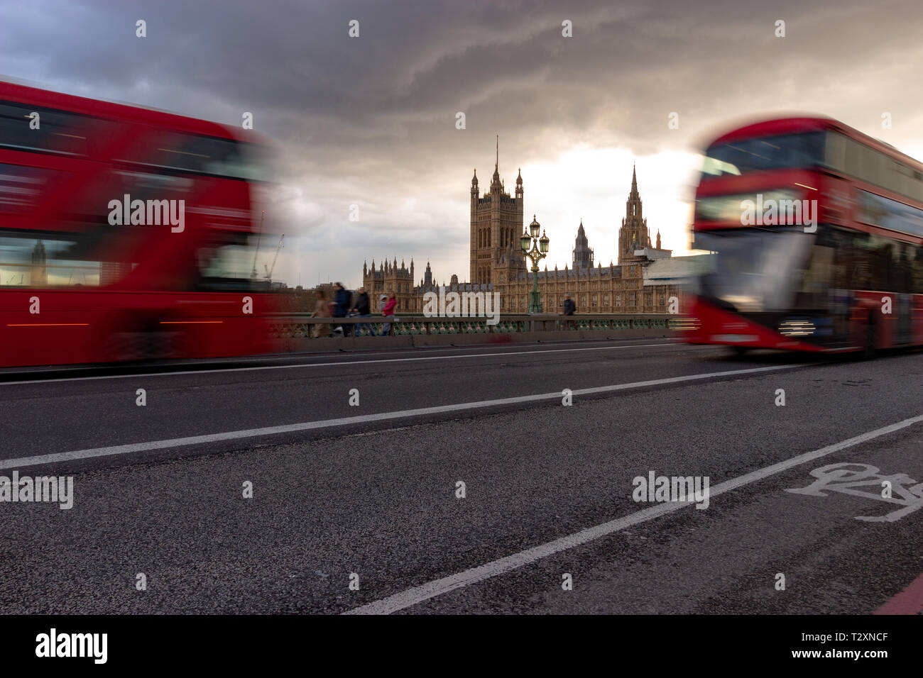 Westminster, Londra, Inghilterra, 3 aprile 2019. Famosi autobus rossi che viaggiano in direzioni opposte attraverso Westminster Bridge con le case del Parlamento Foto Stock