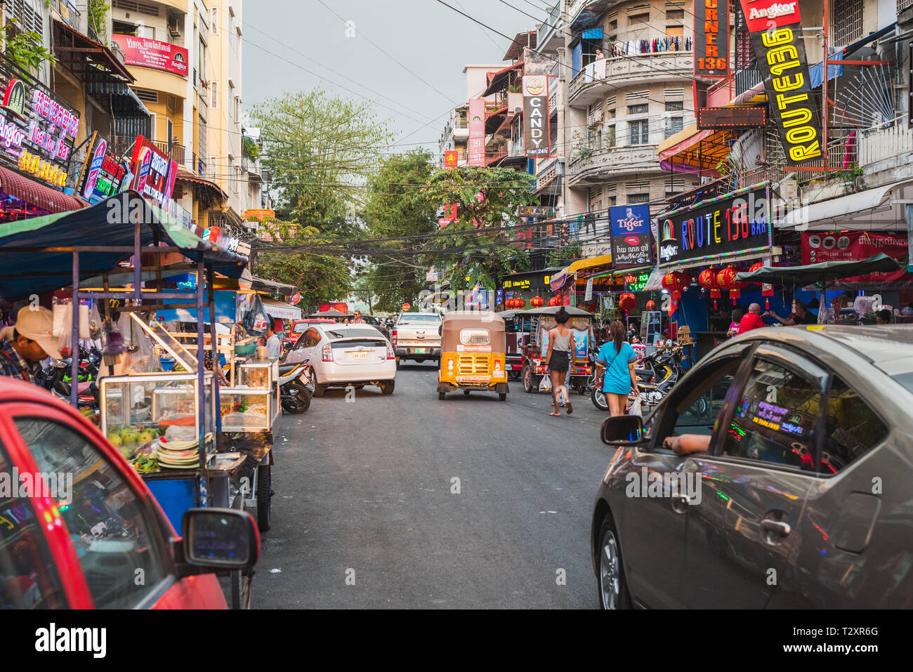 Phnom Penh Cambogia - Gennaio 17, 2019: Street 136 (Oknha In San) con la sua padrona di casa bar, cucina di strada e diversi abitanti nella luce del tramonto. Foto Stock