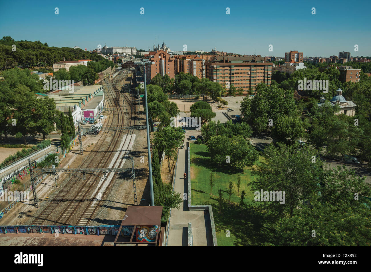 Stazione ferroviaria con binari lunghi tra gli edifici e giardini di legno in Madrid. Capitale della Spagna con vibrante e intensa vita culturale. Foto Stock